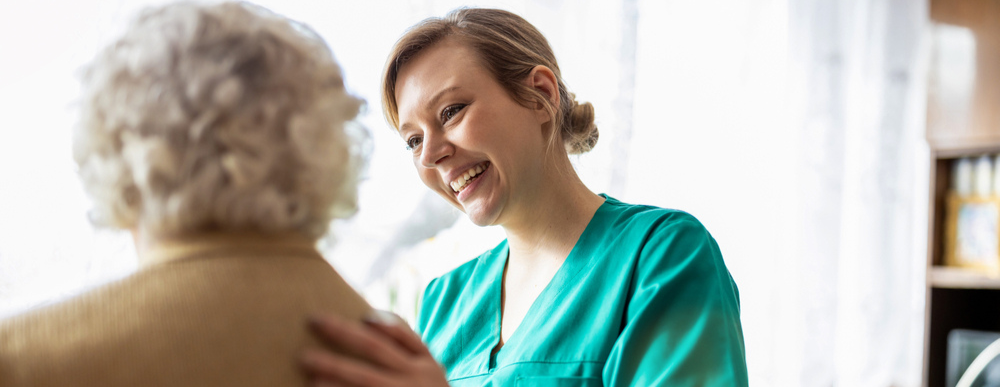 Female carer talking to a senior woman